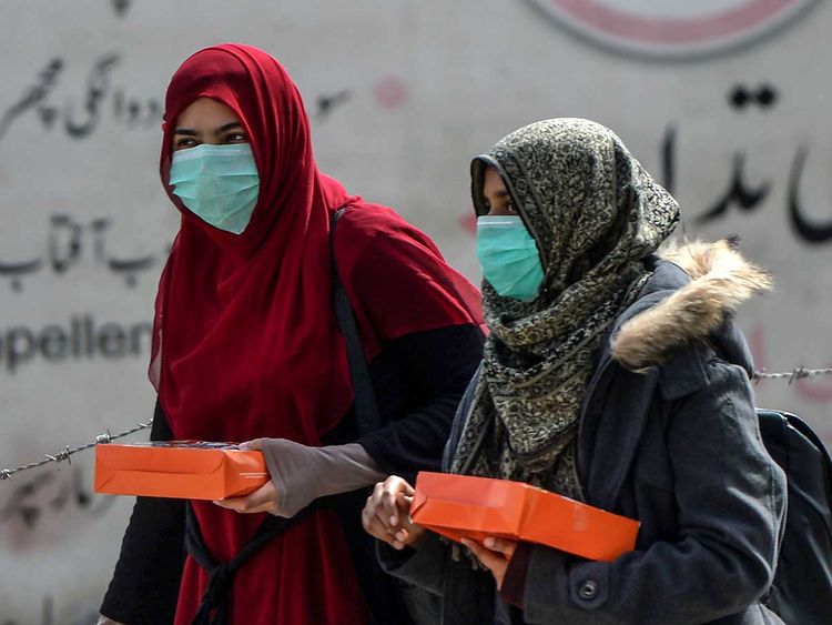 women-wearing-facemasks-as-a-preventive-measure-against-the-spread-of-the-covid-19-coronavirus-walk-along-a-street-in-rawalpindi-on-march-13--2020.-_170f7185de8_large.jpg
